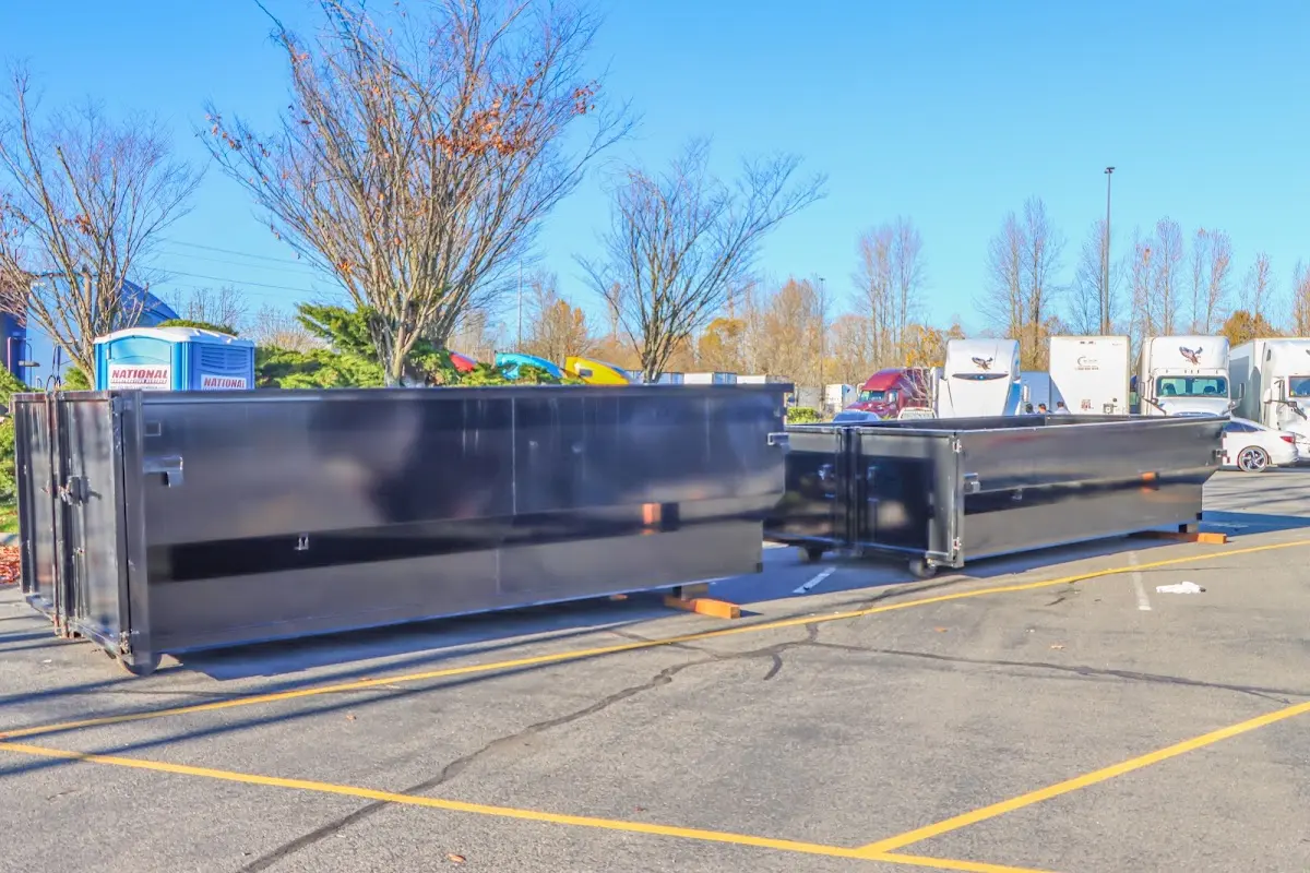 Professional dumpster rental service with roll-off container on residential driveway in Whiskey Creek